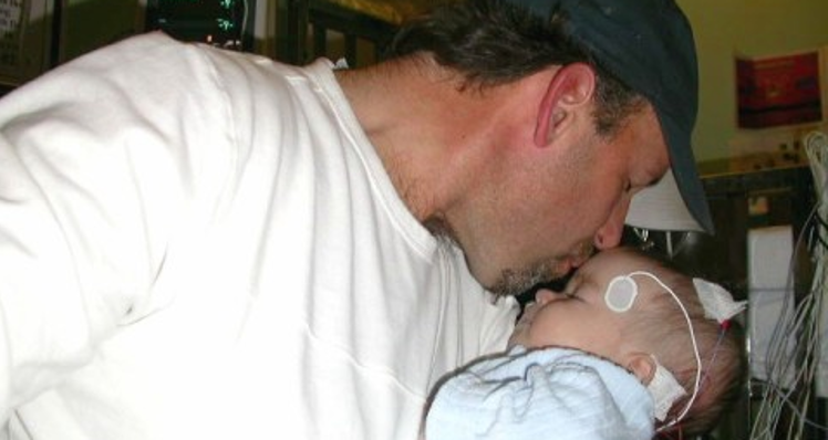Father kissing baby daughter